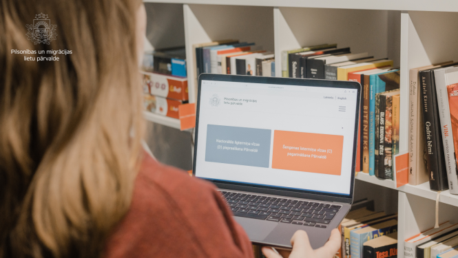 Sieviete skatās datra ekrānā, kurā ir atvērts digitālais ceļvedis trešo valstu pilsoņiem Šengenas vīzu saņemšanai