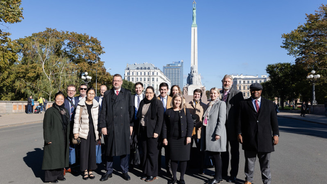 Pasākuma dalībnieku kopbilde pie Brīvības pieminekļa