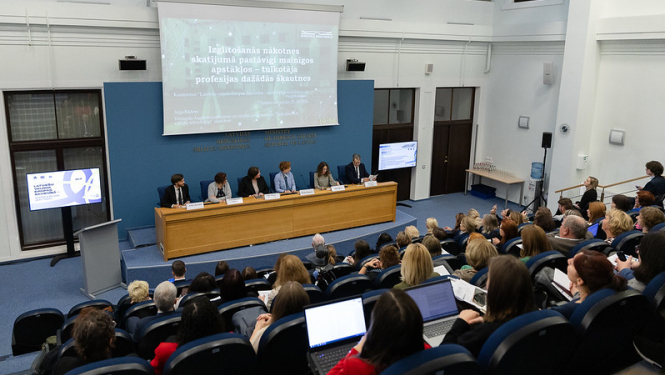 Pasākuma zāles kopskats ar runātājiem un apmeklētājiem