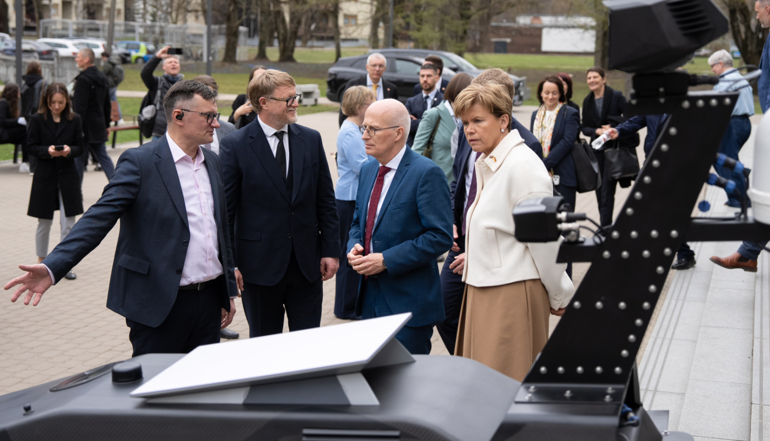 Sanāksmes dalībnieki pie drona