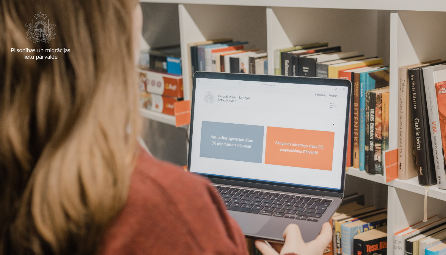 Sieviete skatās datra ekrānā, kurā ir atvērts digitālais ceļvedis trešo valstu pilsoņiem Šengenas vīzu saņemšanai