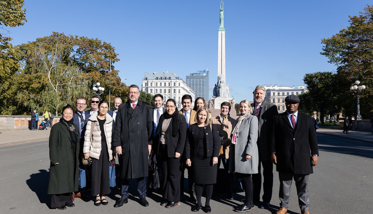 Pasākuma dalībnieku kopbilde pie Brīvības pieminekļa
