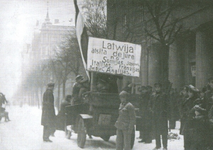 Manifestanti aprīko automobili ar plakātu